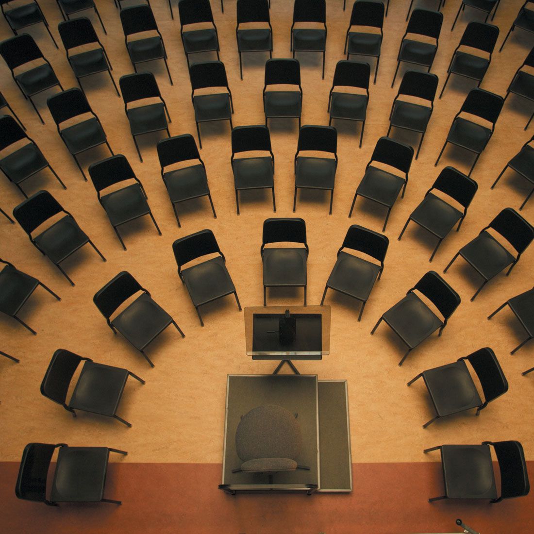 Wenger musician chairs set in orchestra arcs around a podium, seen from above