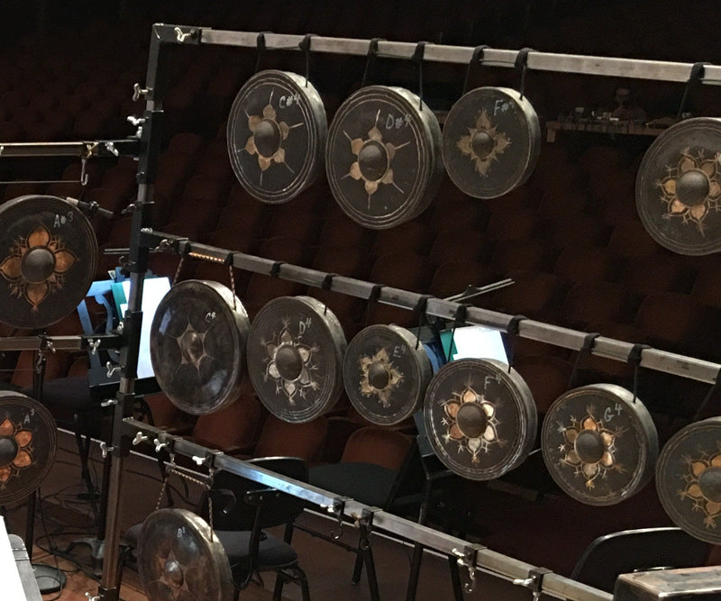 Cal Perc LA tuned gongs racked on stage in chromatic order, each hand-labeled with its pitch from A3 through G4